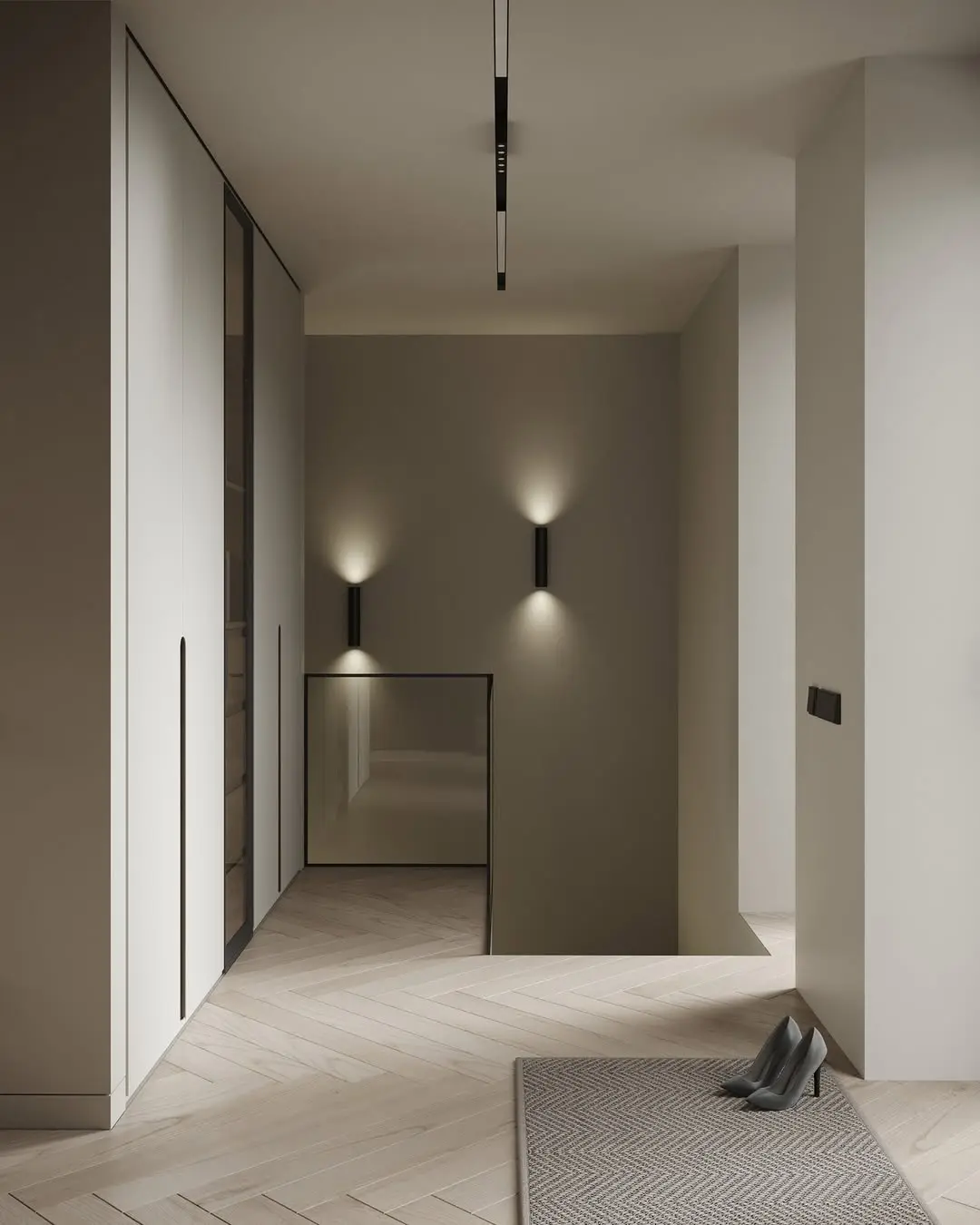 Stylish hallway with herringbone flooring, recessed wall lights, built-in wardrobes, a rug with high heels beside it, and a glass-panel stairwell.